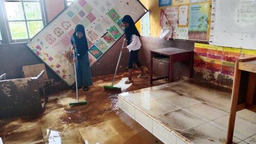 Siswa di SDN 006 Desa Sering Kecamatan Pelalawan, Kabupaten Pelalawan membersihkan sisa banir yang sempat merendam sekolah mereka beberapa waktu lalu. (Foto: Tribun Pekanbaru)